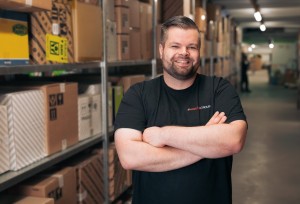 Junger Mann im Lager mit verschränkten Armen.