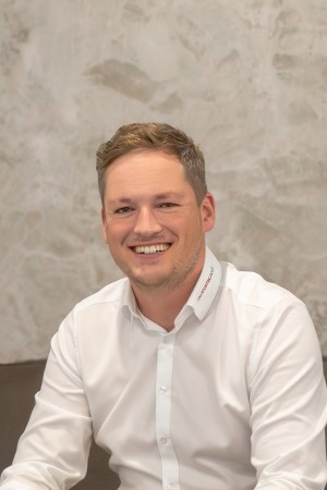 Personalleiter und Prokurist Janis Stöckmann sitzt auf einem Sofa.